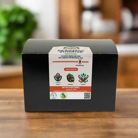 A closed box of Peaceful Sunrise coffee pods on a wooden surface with a label showing the product name and taste notes of cocoa, caramel, and vanilla.