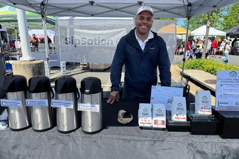 A photo of the founder, Andrew, at the Dulles farmers market in Dulles, VA at the SipSation booth.